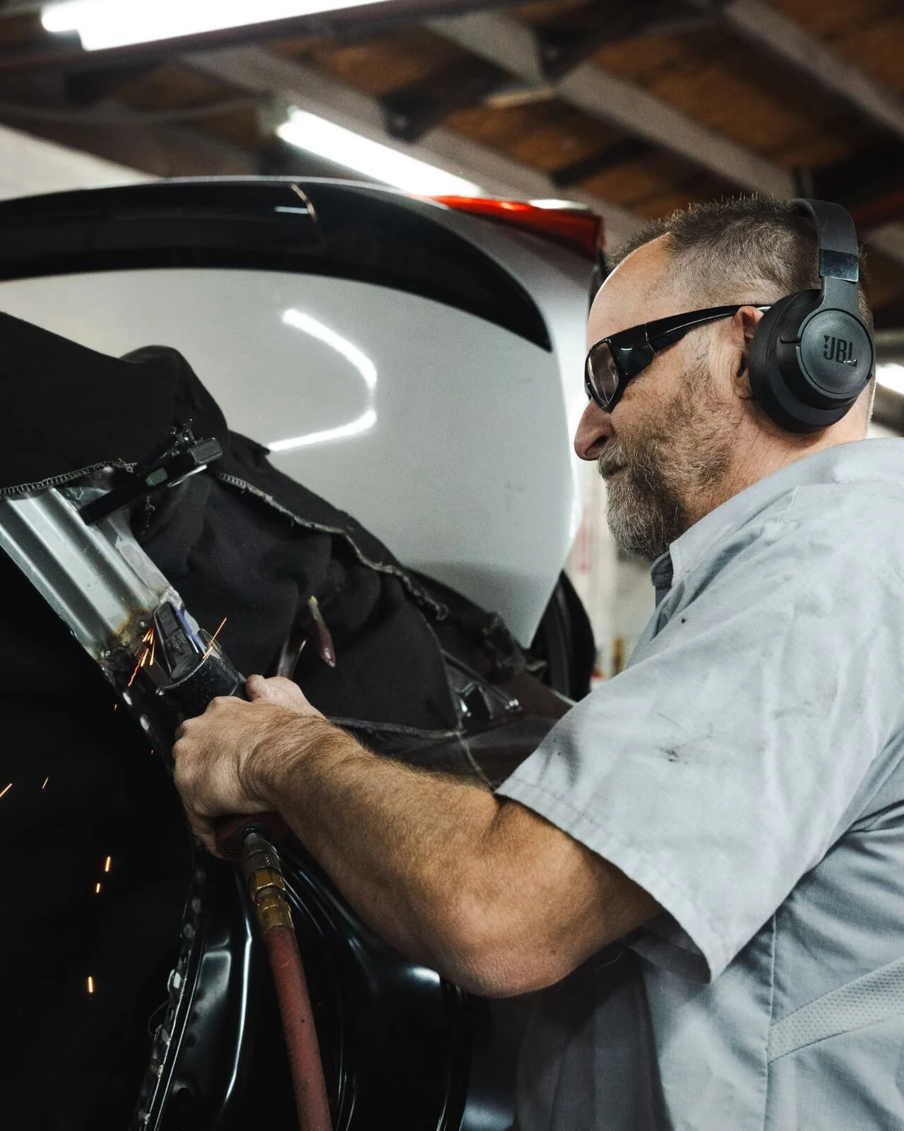 Body technician finishing a welded pillar repair during collision repair