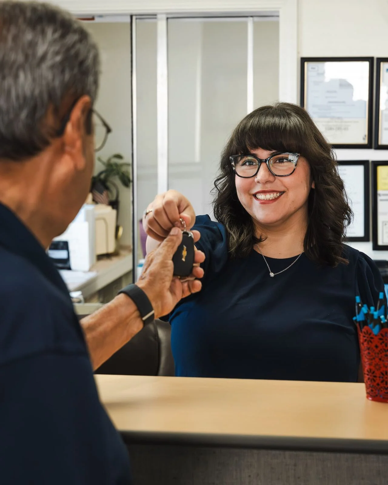 Front office team member handing car keys back to a customer